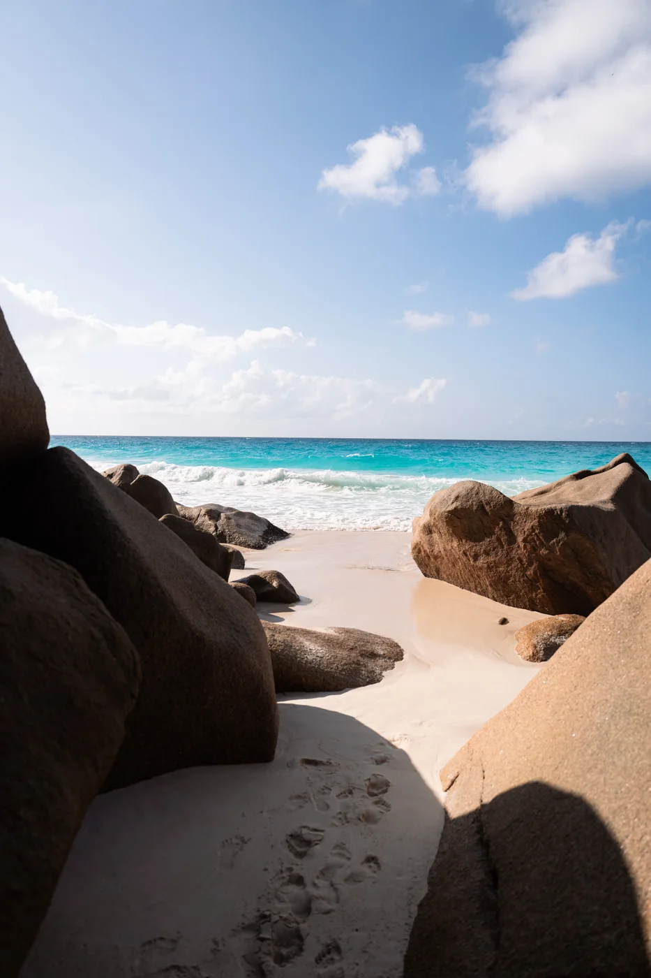 A sandy beach between rocks beside turquoise sea